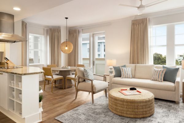 A cozy and modern living space with a kitchen, dining area, and seating. Neutral colors and ample lighting create an inviting atmosphere.