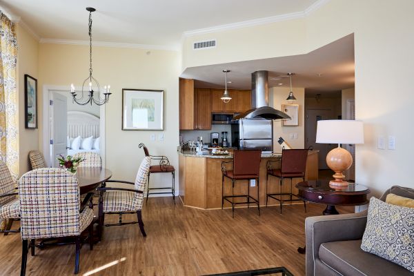 A cozy living space with a dining area, kitchen, and seating, featuring modern decor and warm lighting.