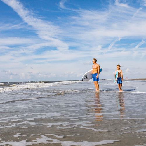 Father and son surfing on beach
