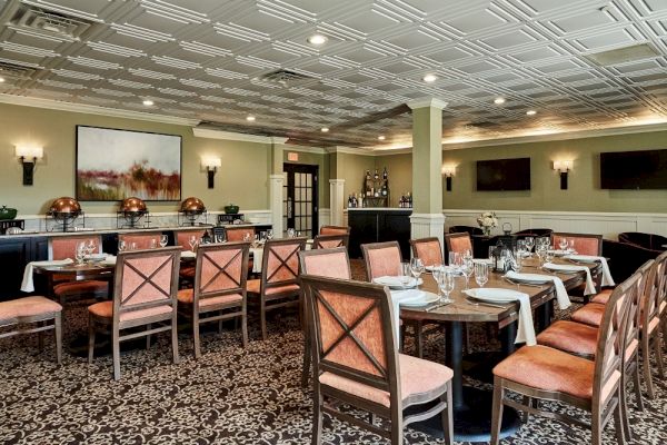 The image shows an elegantly decorated restaurant dining area with arranged tables, chairs, and artwork on walls, perfect for a formal setting.
