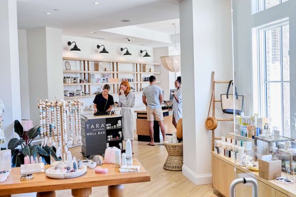A well-lit, modern retail shop with people browsing products, featuring jewelry and various items on display.