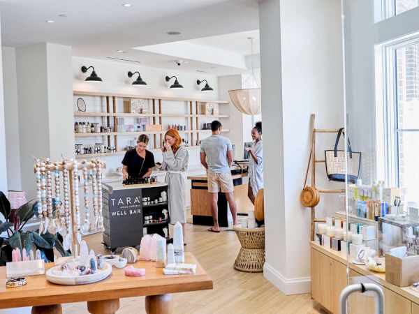 A well-lit, modern retail shop with people browsing products, featuring jewelry and various items on display.