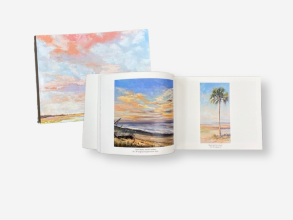 Two art books feature paintings of landscapes, with one open showing colorful sky and palm tree illustrations on a white background.