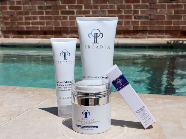 The image features four skincare products from Arcadia, arranged by a pool.