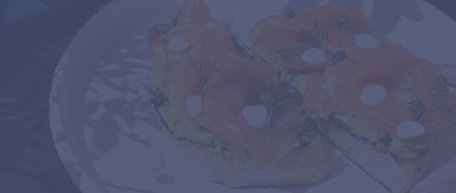 Delicious smoked salmon served on toasted bread with avocado spread, garnished with dill and capers.