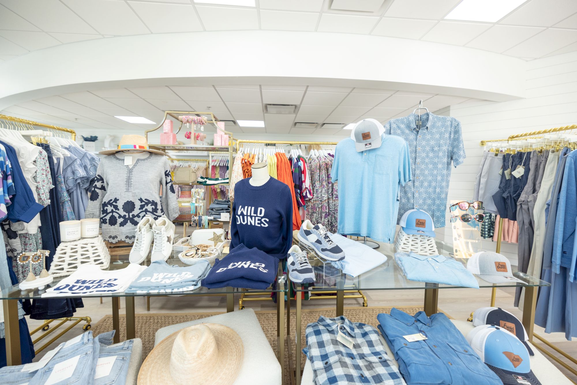 A clothing store display featuring shirts, hats, and various accessories in a range of blue and white shades.